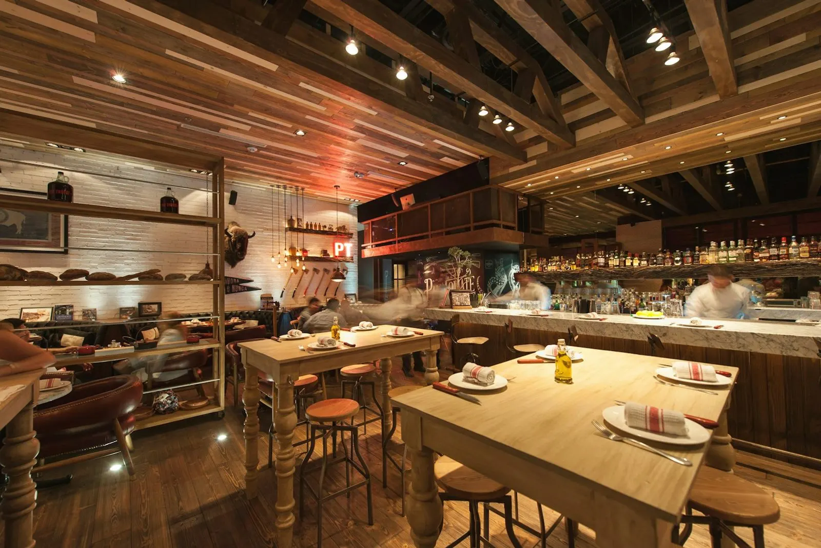 Salón del restaurante con su barra y mesas de madera